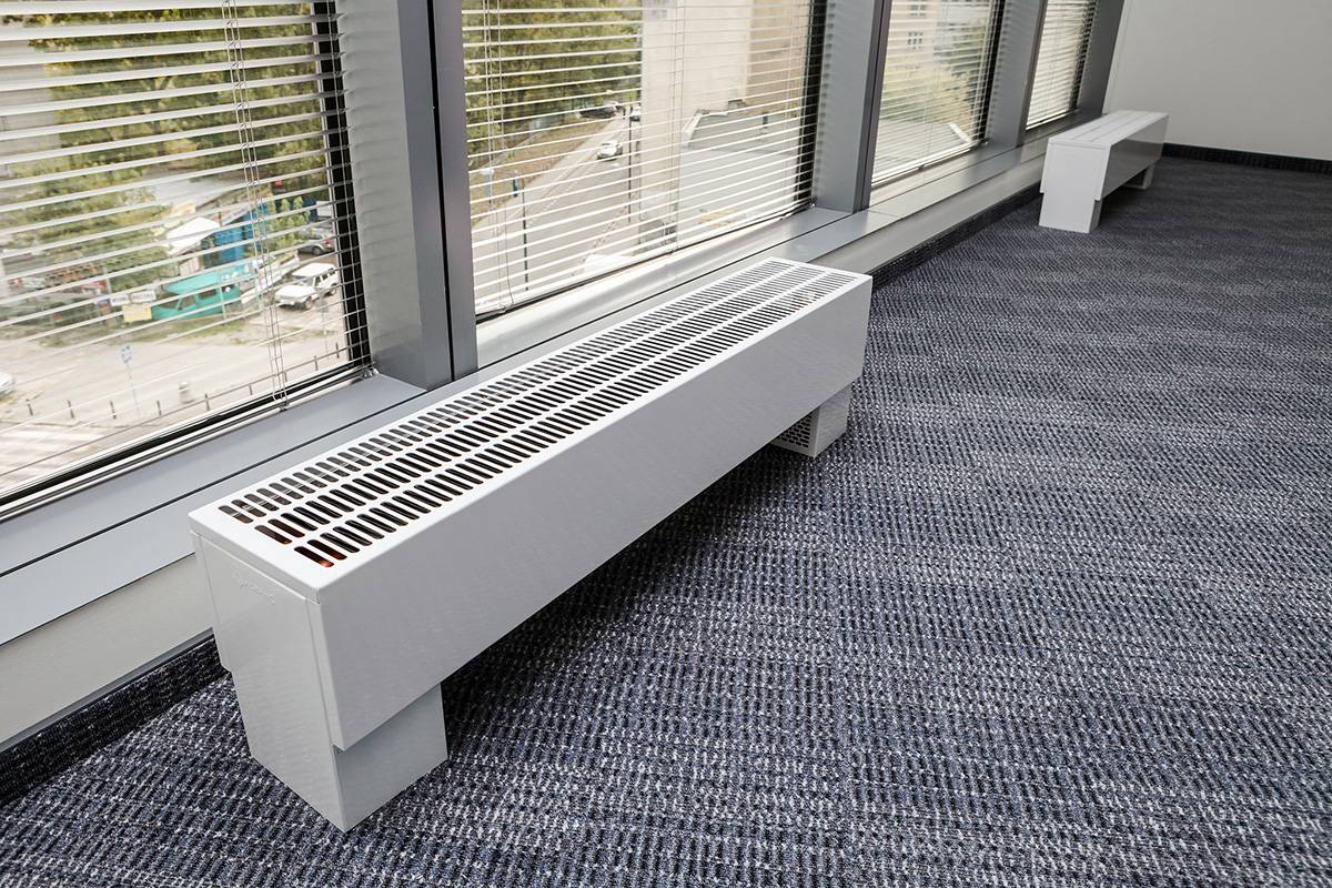 Batterien im Boden: bodenmontierte Einbauheizkörper, unter dem Fenster eingebaute Unterflurgeräte