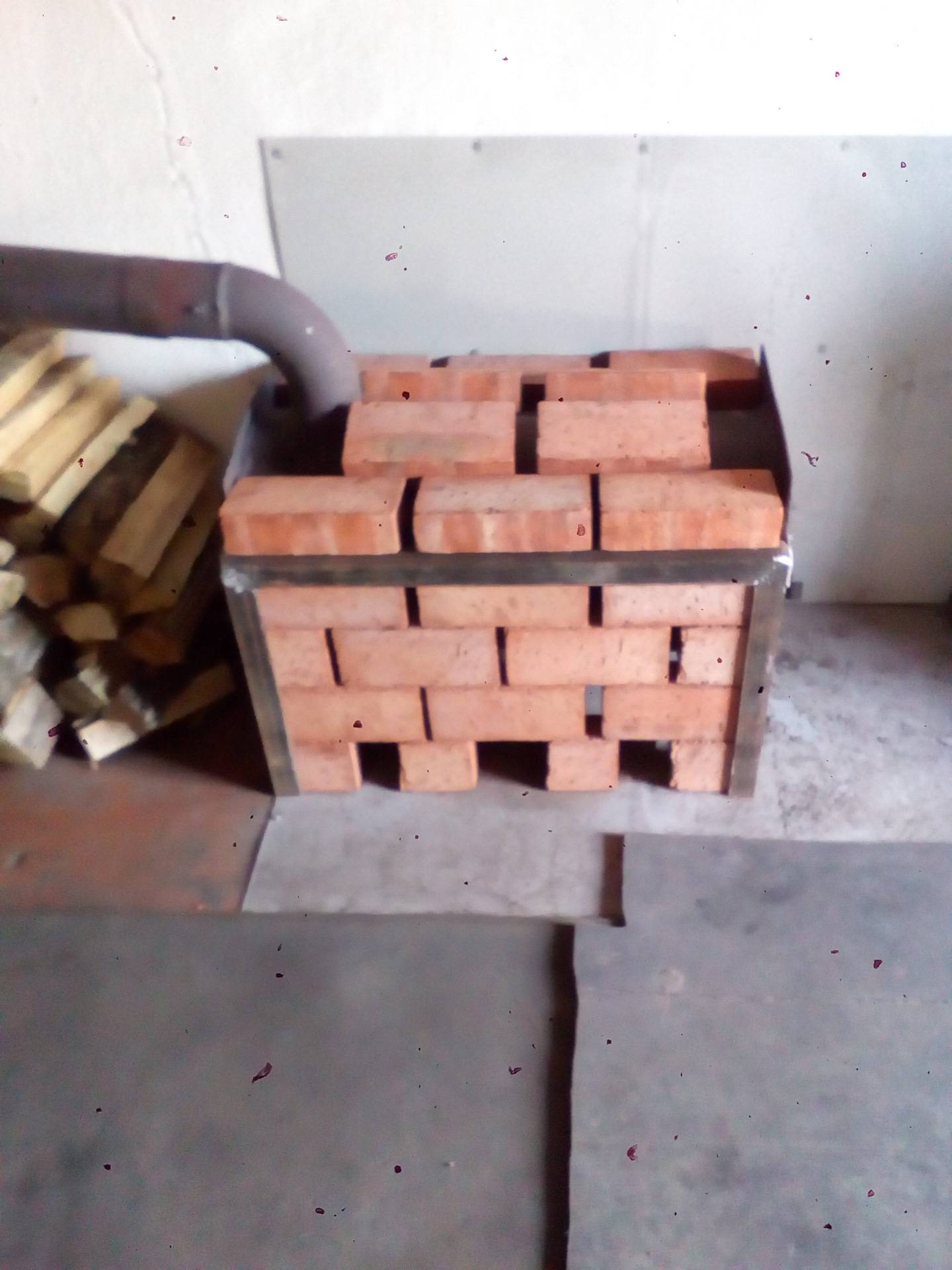 Wie man einen Eisenofen mit einem Ziegelstein überzieht: Was ist möglich, ein Ziegelschutzgitter für einen Gusseisenofen, Heimwerkerverkleidung in einem Haus, Mauerwerksfoto