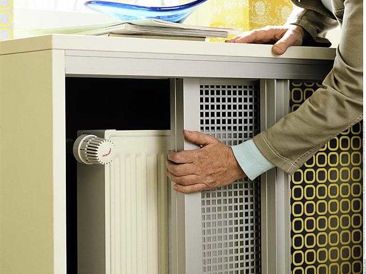 So schließen Sie Heizkörper: Heimwerkerheizkörper in einem Raum mit einem Bildschirm, verstecken Sie Trockenbaurohre vor einem Foto