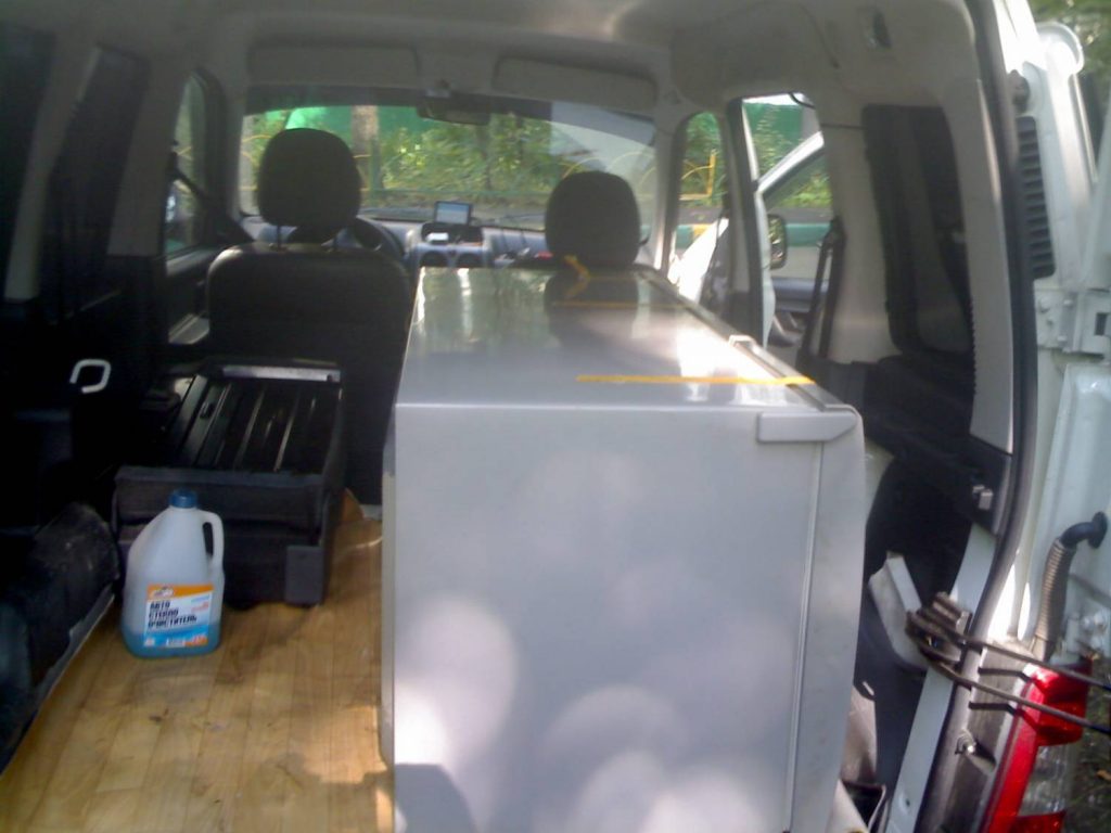 Warum kann ein neuer Kühlschrank nicht liegend transportiert werden und wie kann das Bruchrisiko minimiert werden?